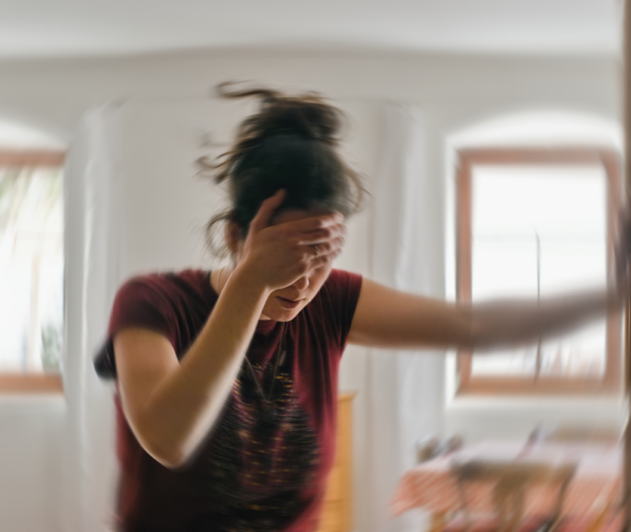 Unscharfes Foto einer Frau, die an Schwindel oder Schwindel oder anderen gesundheitlichen Problemen des Gehirns oder des Innenohrs leidet.