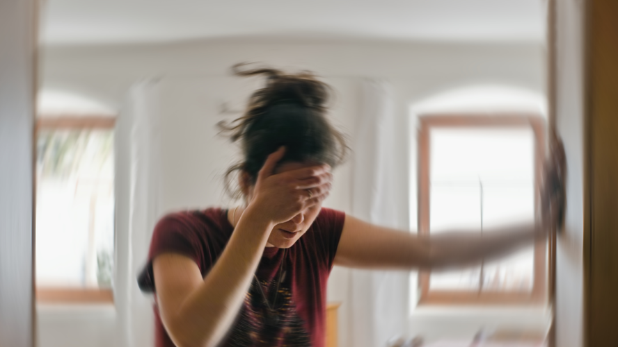 Unscharfes Foto einer Frau, die an Schwindel oder Schwindel oder anderen gesundheitlichen Problemen des Gehirns oder des Innenohrs leidet.