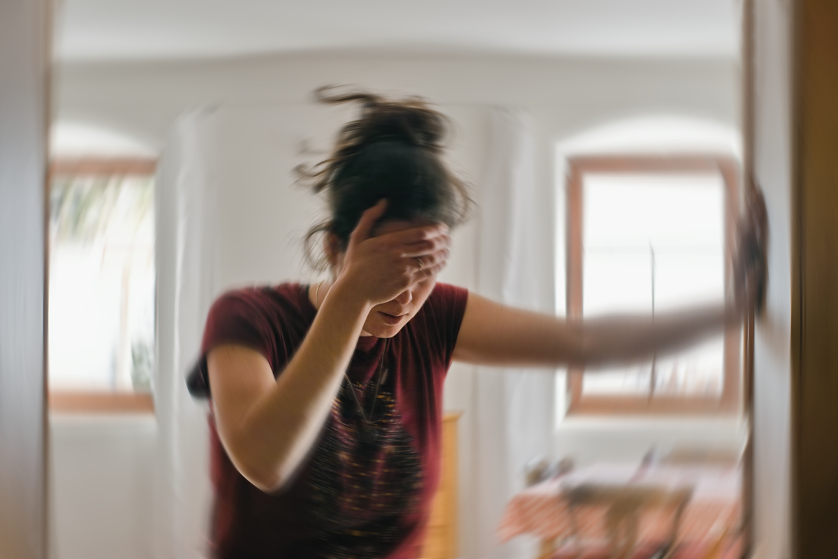 Unscharfes Foto einer Frau, die an Schwindel oder Schwindel oder anderen gesundheitlichen Problemen des Gehirns oder des Innenohrs leidet.
