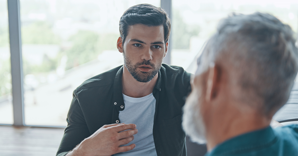 Handsome young man talking to his senior father