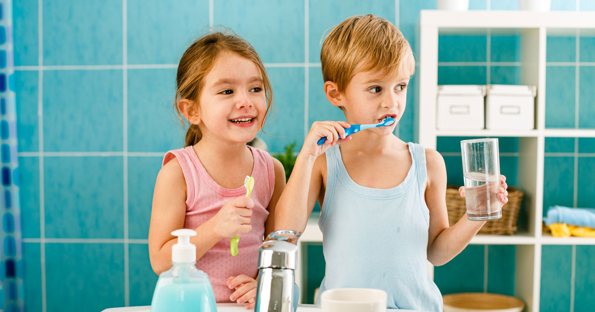 Sibling brushing their teeth in the bathroom together