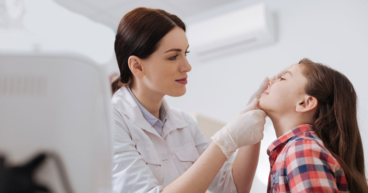 Attentive ENT doctor doing nose exam of her daughter