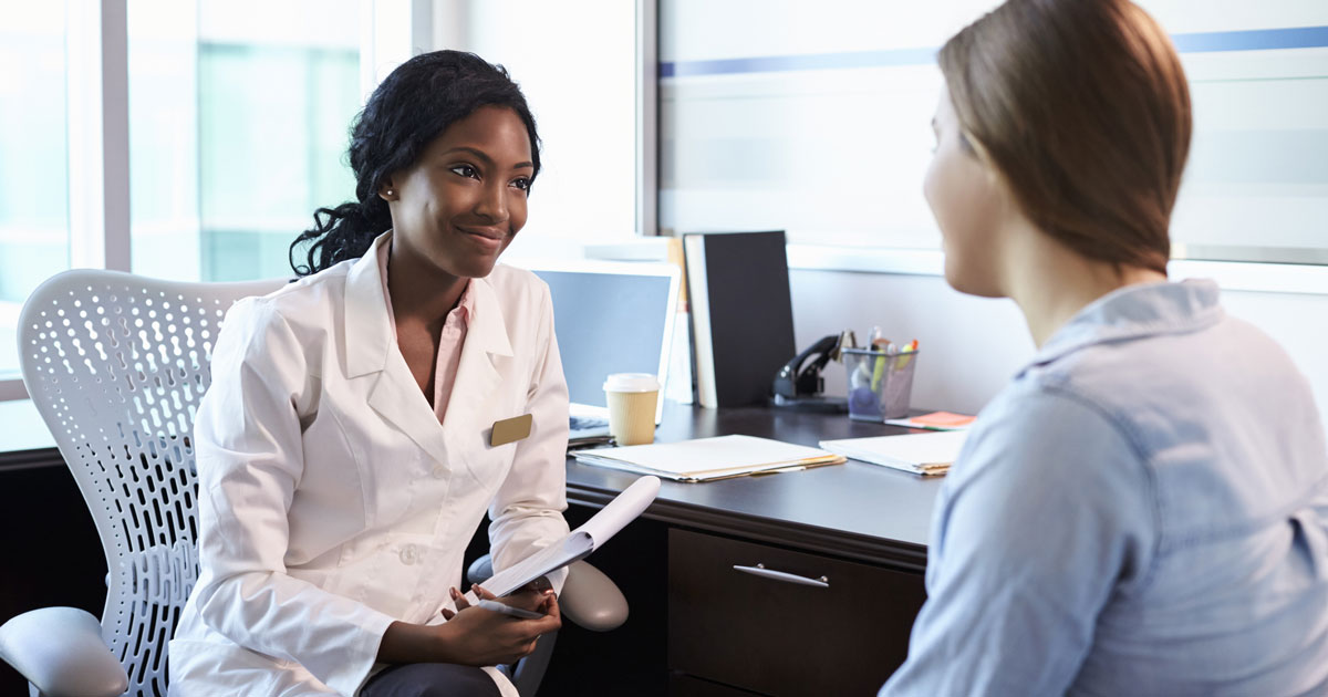 Doctor In Consultation With Female Patient In Office