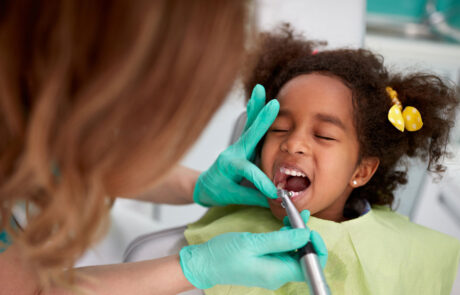 Female dentist patiently polish teeth to child