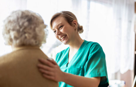 Friendly nurse supporting an elderly lady