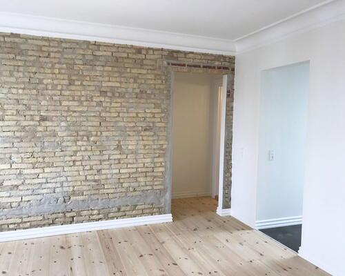 Renoveret 3-værelses med Svane-køkken, gulvvarme og blotlagte murstensvægge – 74 m2 tæt på byliv