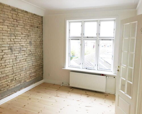 Renoveret 3-værelses med Svane-køkken, gulvvarme og blotlagte murstensvægge – 74 m2 tæt på byliv