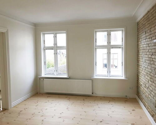 Renoveret 3-værelses med Svane-køkken, gulvvarme og blotlagte murstensvægge – 74 m2 tæt på byliv