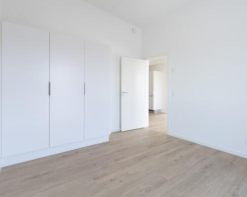 Større treværelses lejlighed med et centralt køkken-alrum i åben forlængelse med stuen. Lejligheden har et stort soveværelse samt et mindre værelse, bad og altan/terrasse. Til boligen hører eget skur.