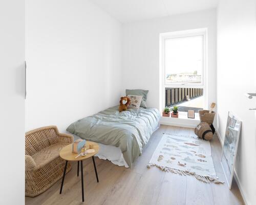 Skøn fireværelses lejlighed med lyst køkken-alrum og stue, reelle værelser, bad, entré og egen altan. Til boligen hører eget skur.