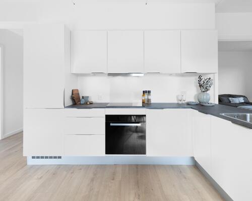 Rummelig fireværelses lejlighed med stort køkken-alrum, gode værelser, stilrent bad og egen altan. Til boligen hører eget skur.