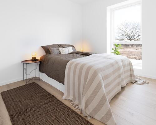 Rummelig fireværelses lejlighed med stort køkken-alrum, gode værelser, stilrent bad og egen altan. Til boligen hører eget skur.