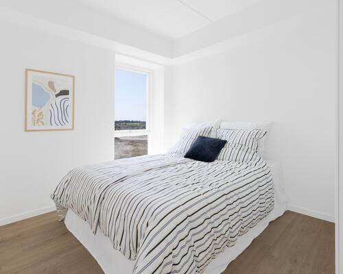 Større toværelses lejlighed med stort og lyst køkken-alrum, stort soveværelse, badeværelse, entré samt egen altan/terrasse. Til boligen hører eget skur.