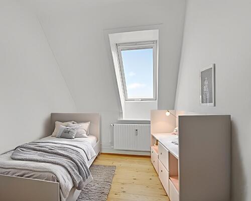 Lys 3-værelses taglejlighed med charmerende plankegulve og godt lysindfald – tæt på indkøb og bus