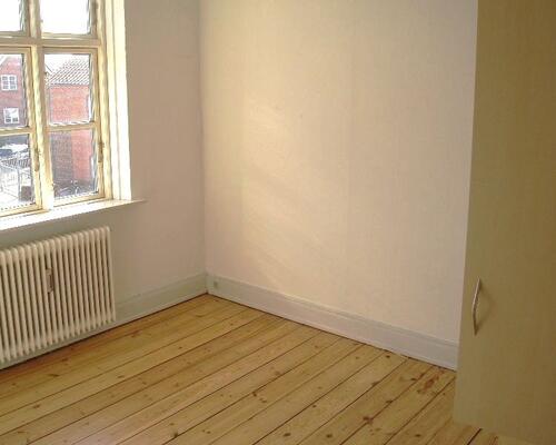 Stor men ældre 3-vær. lejlighed lige udenfor volden. Huslejen er inkl. vand.