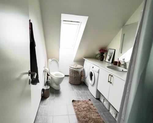 Lys lejlighed med synlige bjælker.