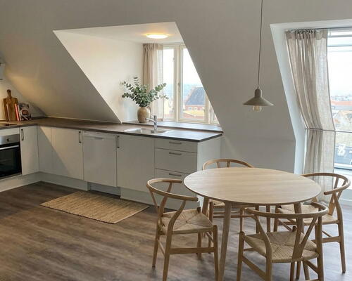 Lys lejlighed med synlige bjælker.