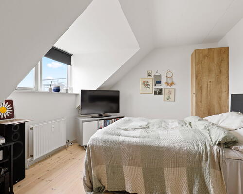 Lys og rummelig 3-værelses med charmerende skråvægge, fransk altan og moderne bekvemmeligheder – 94 m2