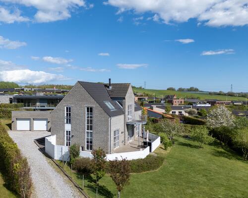 Lys arkitekttegnet villa med ugeneret udsigt over det åbne landskab