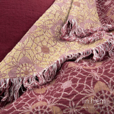 Linpledd i rød og gul farge, blomstrete.