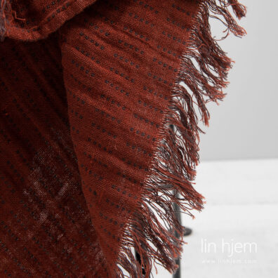 Tosidig rødt pledd i lin med frynser.