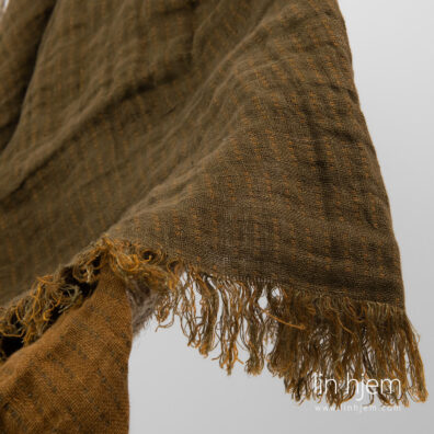 Mønstret tosidig brunt linpledd med frynser.