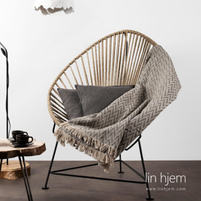 Halvlin pledd med grått sikksakk mønster.