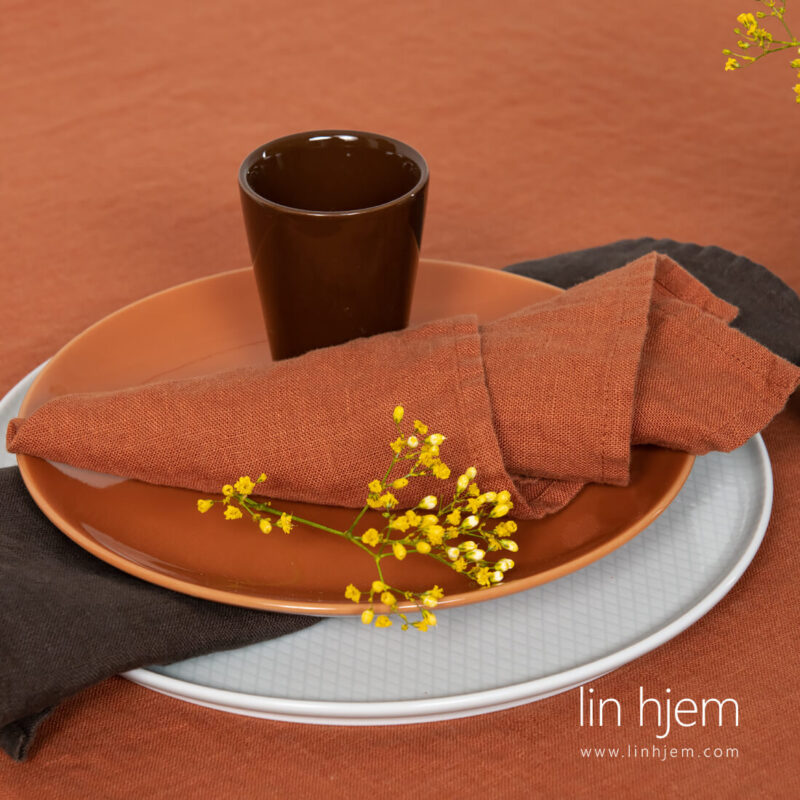 M&oslash;rkeoransje serviett i vasket lin.