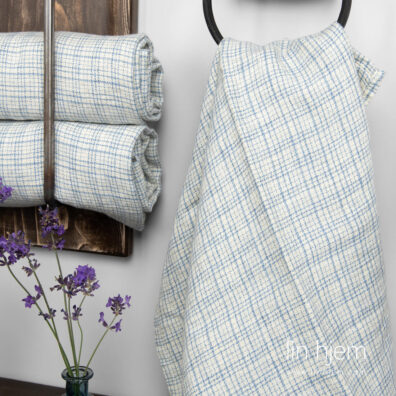 Gulaktig lin håndkle med blå ruter.