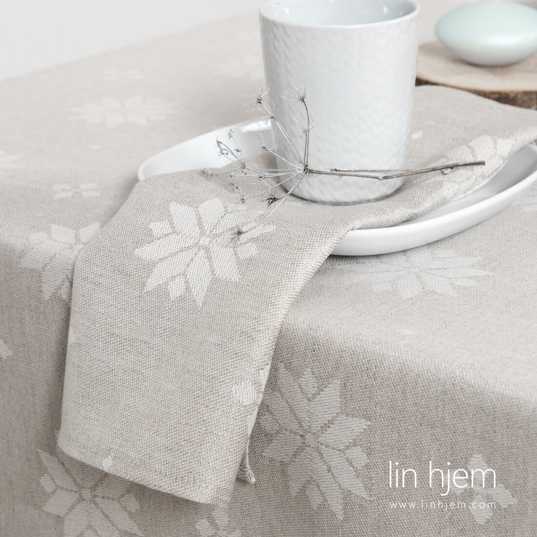 Halvlin lysegrå serviett med stjerner.