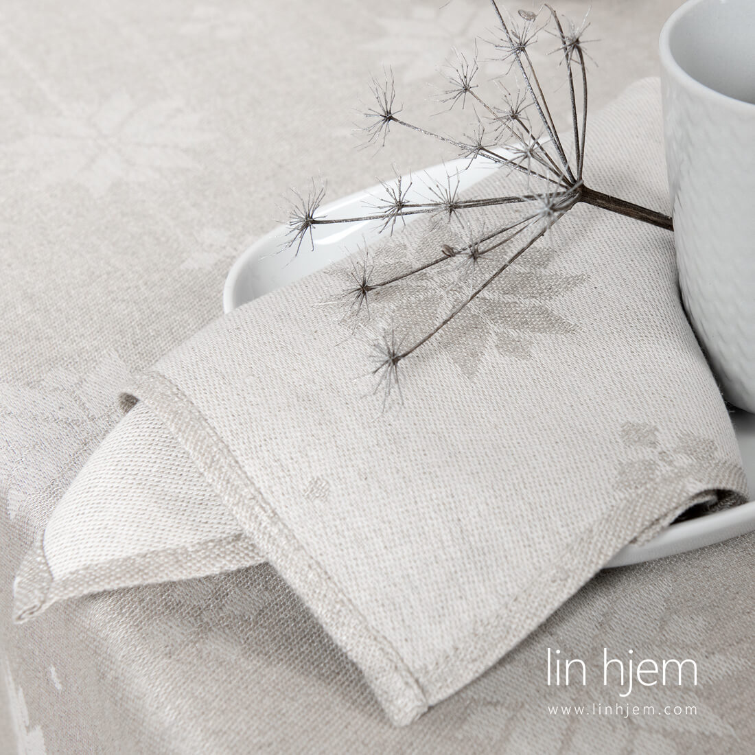 Halvlin serviett i lys grå farge, med stjerner.