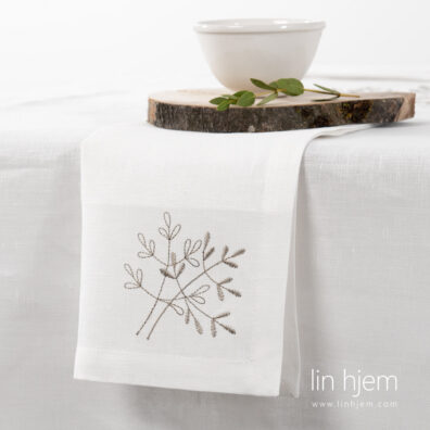 Melkehvit brodert linserviett.