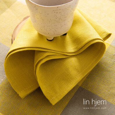 Halvlin serviett i gul farge.