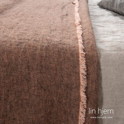 Sengeteppe i brun farge.