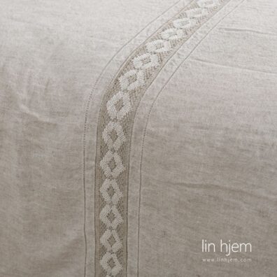 Grått sengesett med blonder.