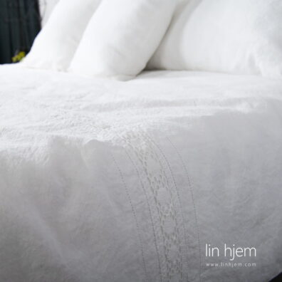 Kritthvitt sengesett med blonder.