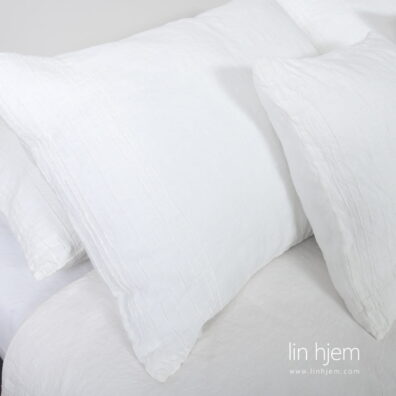 Hvitt sengesett i hullmønster.