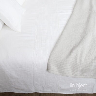 hvitt hullmønstret sengesett.