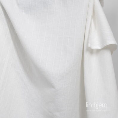 Halvlin vasket stoff i melkehvit farge, stripete.