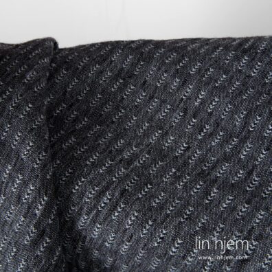 Linstoff i svart/grå farge, vasket, mønstret.