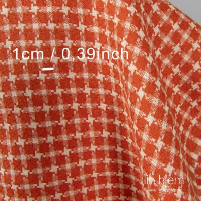 Mønstret linstoff i rød farge.