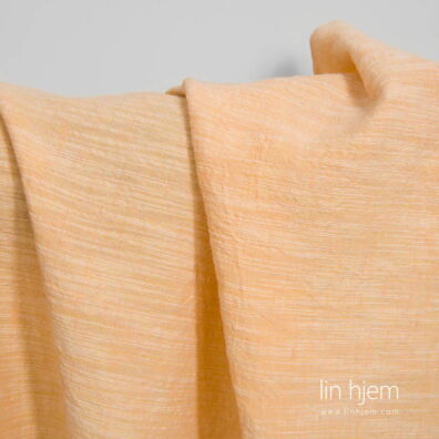 Bredt vasket halvlin stoff i lys oransje farge.