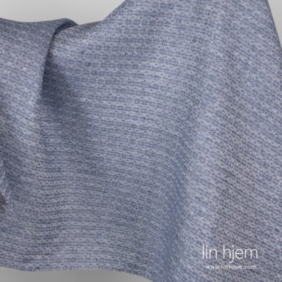 Blått linstoff med snøfnugg.