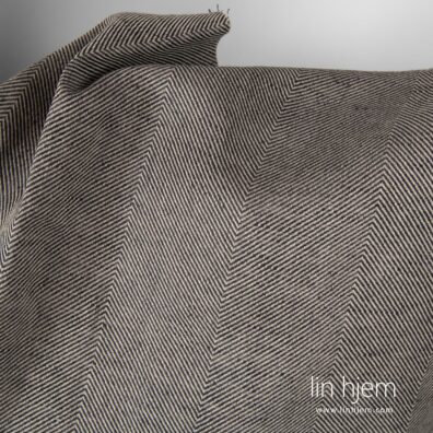 Mønstret halvlin stoff i mørk grå farge.