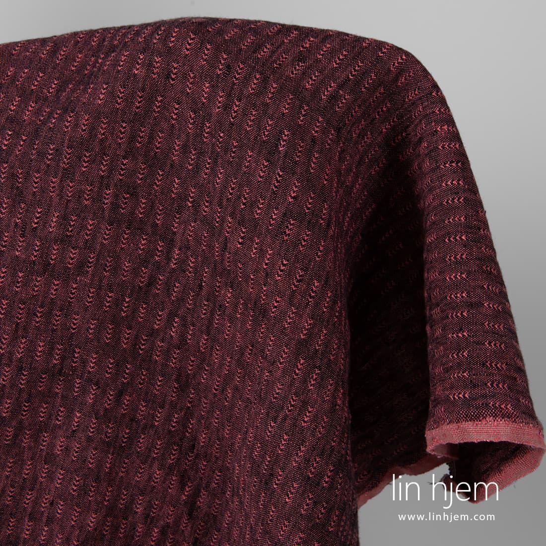 Svart/rødt vasket linstoff, mønstret.