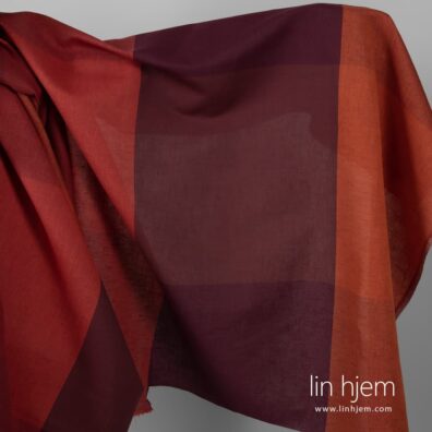 Bredt stoff med oransje/rød striper.