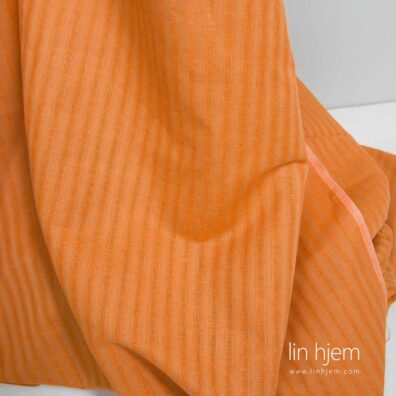 Oransje farget halvlin stoff med striper.
