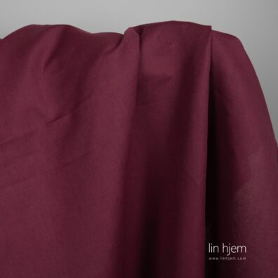 Halvlin stoff i mørk rød farge.