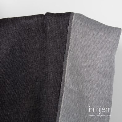 Tosidig grått-svart linstoff med prikker.