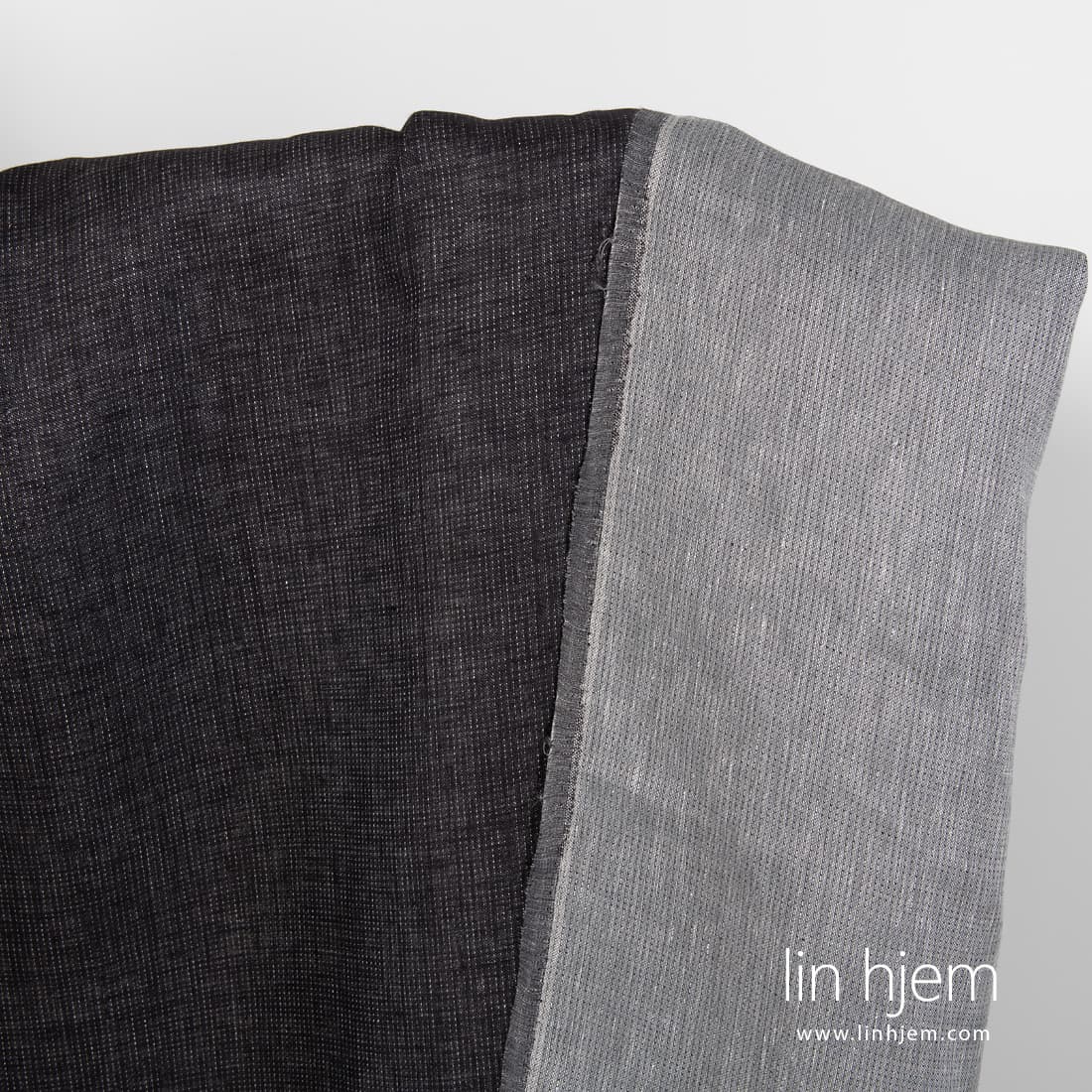 Tosidig grått-svart linstoff med prikker.